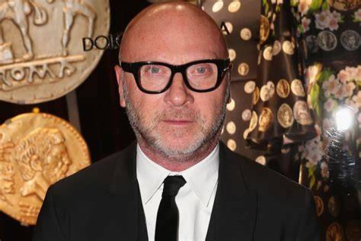 Domenico Dolce with his arm around Sutton Stracke in front of her boutique establishment.
